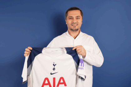 Bild zeigt, wie Dr. Abdulaziz Balwi ein Trikot des Premiere League Klubs Tottenham Hotspur in beiden Hände hält